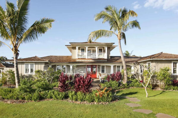 A large white house with palm trees in the yard.