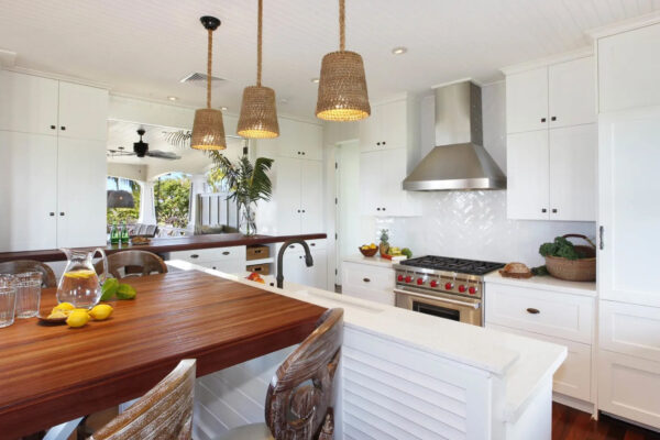 A kitchen with white cabinets and wooden island.