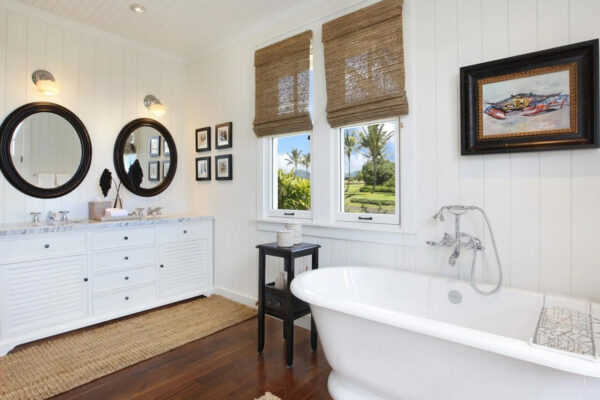 A bathroom with a tub, sink and mirror.